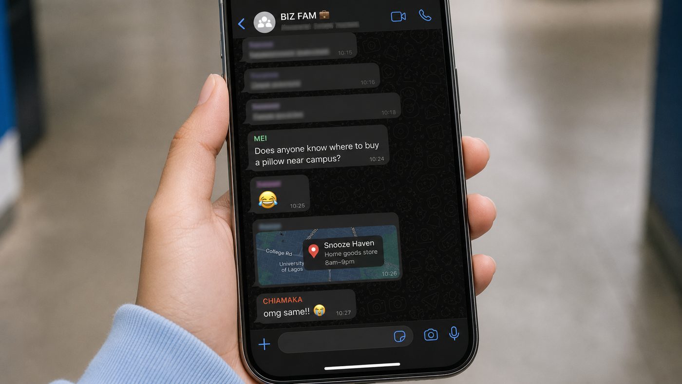 A hand holding a phone showing a friendly WhatsApp group conversation.
